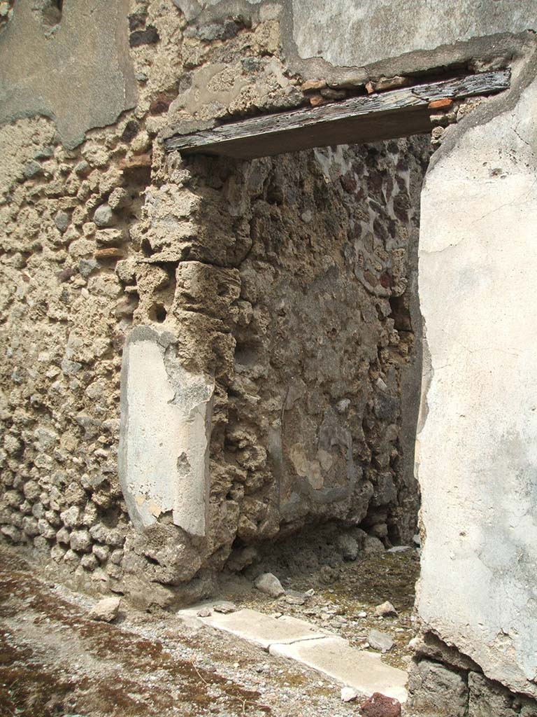 IX.5.17, Pompeii. May 2005. Entrance doorway. The exterior plastered zoccolo was painted black.
The door threshold was made from a slab of marble, with holes for the hinges.
