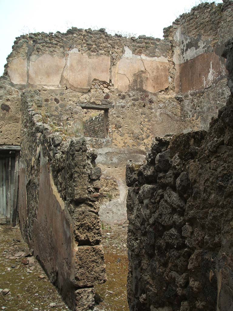 IX.5.17/6 Pompeii. May 2005. Looking north along corridor y to doorway to garden u.  
Doorway to the stable q leading to room x is on the right.
The upper floor, above the stable, shows the remains of the zoccolo and of the white middle zone of the walls.

