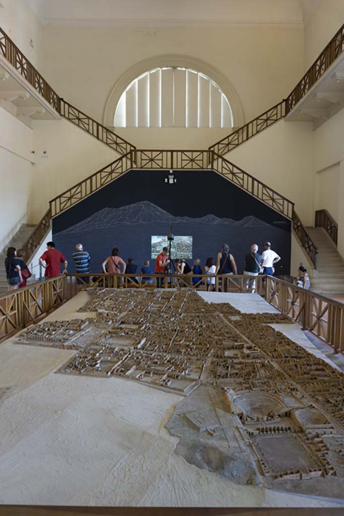 Cork model on display on Naples Archaeological Museum. July 2017.
Looking north from Gladiators Barracks and Theatres at VIII.7 on Via Stabiana, lower right.
Foto Annette Haug, ERC Grant 681269 DÉCOR.
This model in the Naples Archaeological Museum, made of wood, cork and paper, by Felice Padiglione, is scaled at 1/100, and shows the excavations up until the end of 1879.

According to the Archaeological Park of Pompeii display notice in an exhibition in VIII.2.14/16 in 2018, featuring a cork model of VIII.2, - the Houses of Championnet, Sarno Baths, and the next few Houses on the southern slope -
“The cork model was begun in 1865 by Giovanni Padiglione, one of several models predating the great model of the entire city now in Naples Archaeological Museum. 
It was created over the course of several stages, following the advance of archaeological discoveries, as demonstrated by the Courtyard of the Moray Eels, excavated at the end of the nineteenth century, and the lower floors of the houses which were investigated in the 1930’s.
In addition, the wall and floor decorations, painted on paper, do not correspond with those that were originally present; most probably it was decided to substitute them with those of a more profound impact from other houses, for educational purposes.”

