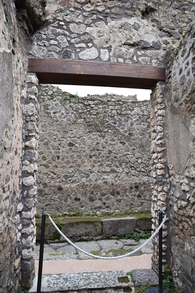 IX.5.21, Pompeii. March 2018. 
Looking west through entrance doorway onto Vicolo di Tesmo, from corridor “q”.
Foto Annette Haug, ERC Grant 681269 DÉCOR.
