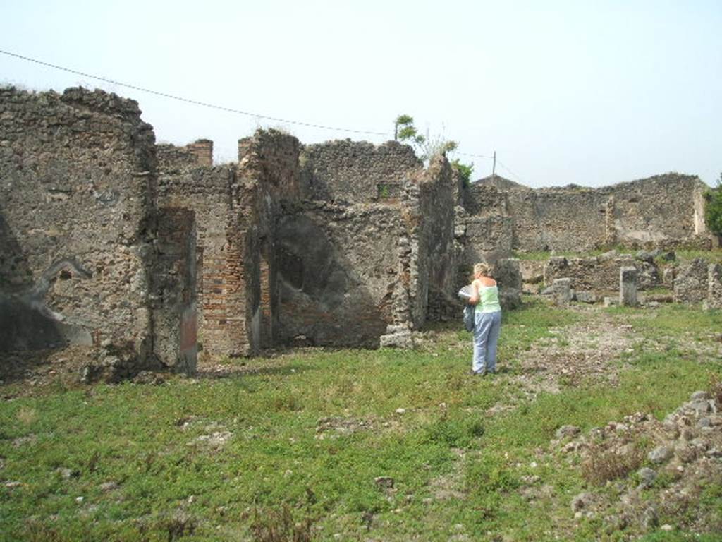 IX.6.4, IX.6.3 and IX.6.g Pompeii. May 2005. Looking west from IX.6.g.
South-east corner of kitchen area of IX.6.4, approximately where the figure is standing.



