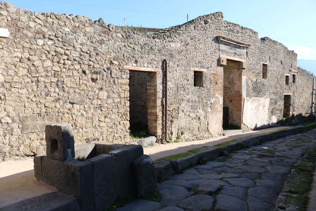 IX.7.17 Pompeii right of fountain, then IX.7.16 and IX.7.15, on right. December 2018. 
Looking south along east side of Vicolo di Tesmo. Photo courtesy of Aude Durand.

