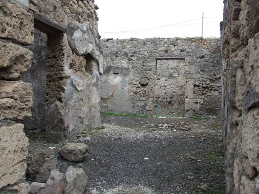 IX.7.19 Pompeii. May 2005. South-east corner of room a, cubiculum. According to Mau, room a, and room b, had walls painted with a simple decoration of the last style on a white background. Room a was called a cubiculum but the design on the flooring did not indicate the place of the bed. The flooring in this cubiculum had been made of a crushed lava stone outlined with white stones, the carpet design forming a net of octagons and squares. 
It was well conserved and so seemed not to have been very old when buried by the eruption. The wall decoration of the last, IV style, on a background of sea-green was conserved only in the upper part. On the lower part it had fallen and a decoration of the first style had reappeared on the street (west) wall. This showed a yellow lower band and traces of the peacock-blue/purple band protruding out that separated it from the coarse stucco of the rest of the wall.  On the other walls was a simple white stucco. All the antique stucco had been perforated to make the new stucco adhere to it. See Mau, BdI 1883, (p.80). See Bragantini, de Vos, Badoni, 1986. Pitture e Pavimenti di Pompei, Parte 3. Rome: ICCD. (p.502)
