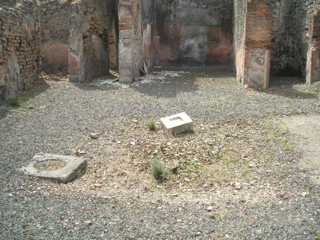 IX.7.25 Pompeii. May 2005. Looking south across atrium "2", with remains of impluvium. On the left is the doorway to room “q”, then the entrance to corridor “p”, the tablinum “o”, and the doorway to small room “m”.
