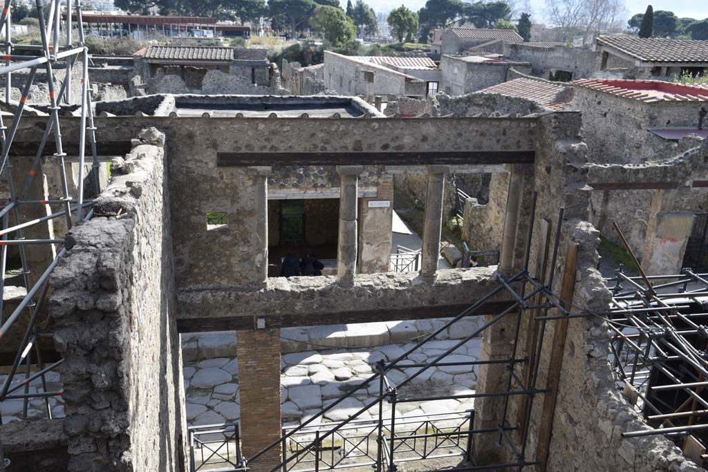 IX.12.2 Pompeii, on left, doorway to stairs to upper floor, with IX.12.1, entrance in centre. February 2017. 
Looking south across Via dell’Abbondanza. Photo courtesy of Johannes Eber.
