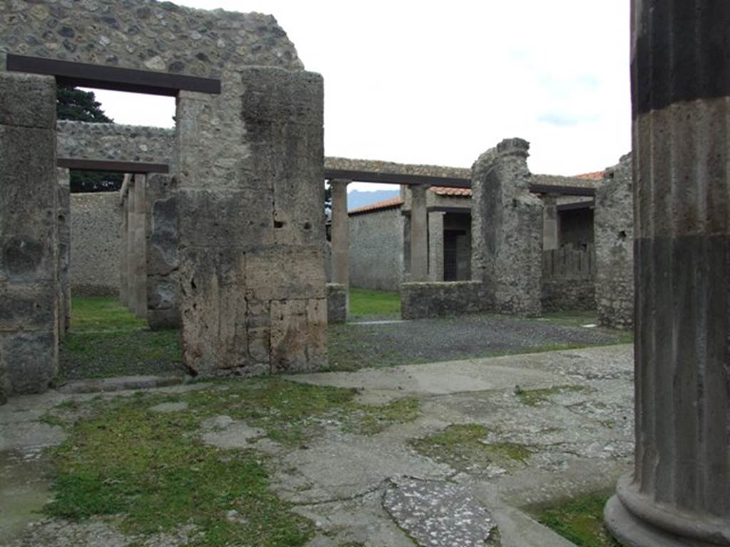 IX.14.4 Pompeii. December 2007. Looking south from the atrium at corridor I on the east of the tablinum H and through the tablinum towards the peristyle 1. The holes left by the removal of the two of the four figured bronze fittings can be seen on the pillar, left of centre.