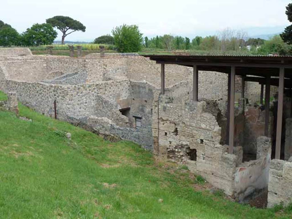 IX.14.c Pompeii. May 2010. Room 4, room to north of fauces, with stone staircase to its north. Wall on west side of insula, showing IX.14.2/4, IX.14.b (blocked entrance in low wall) and north side of IX.14.c.