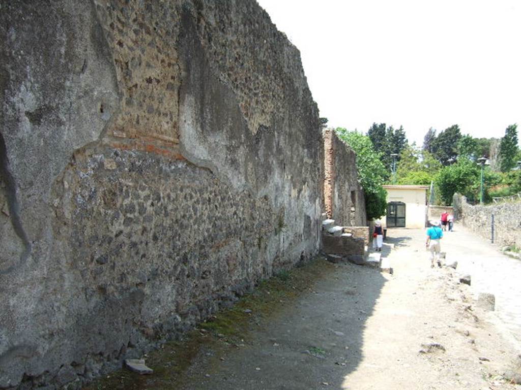 HGW24 Pompeii. May 2006. Via dei Sepolcri looking north to steps of entrance. 
Just beyond is the doorway of entrance HGW25.
On the other side of the roadway, on the right of the photo, no. 97 and 91 from the La Vega plan were found. 
