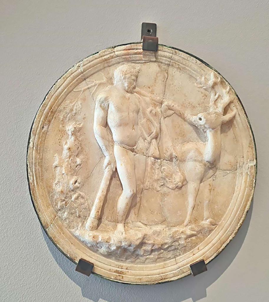 Villa of Diomedes, Pompeii. October 2023.
Marble decorative hanging relief (oscilla) showing Hercules and the hind of Ceryneia. Photo courtesy of Giuseppe Ciaramella. 
On display in “L’altra MANN” exhibition, October 2023, at Naples Archaeological Museum.
