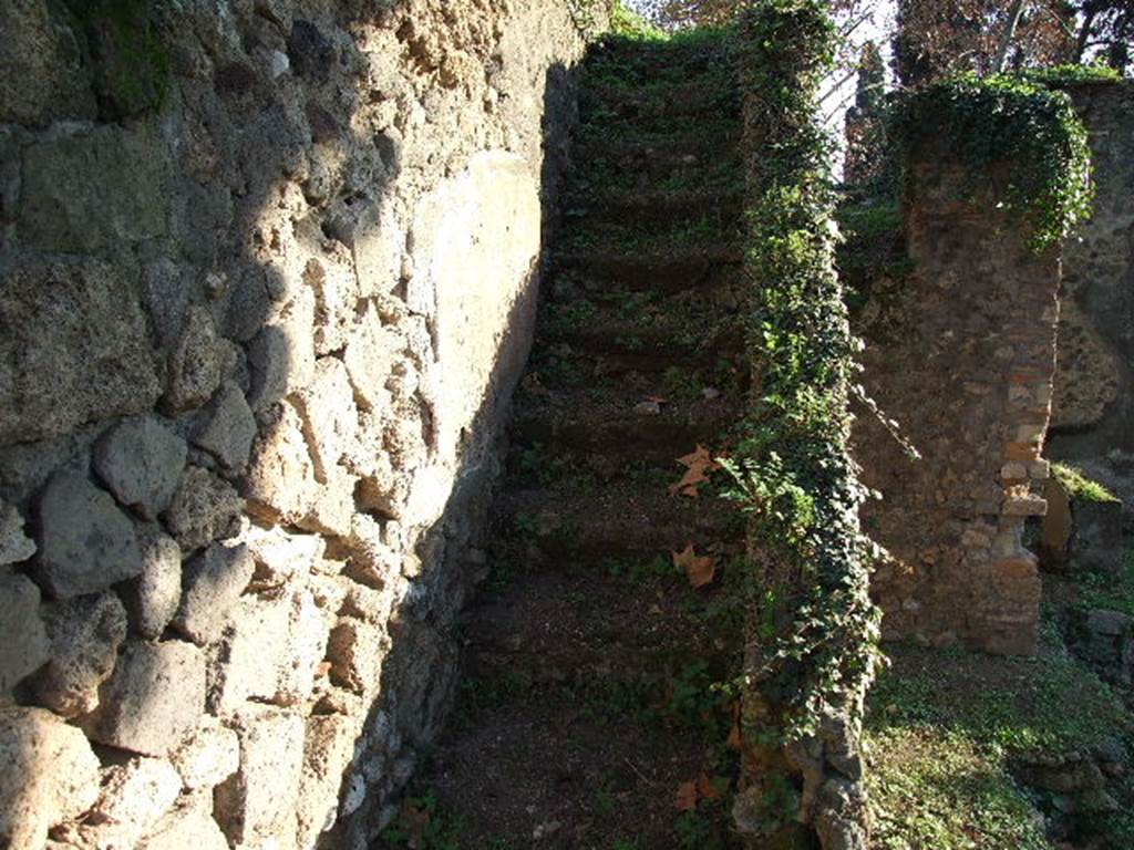 HGE12 Pompeii. December 2006. Staircase against east wall of courtyard with lararium.  