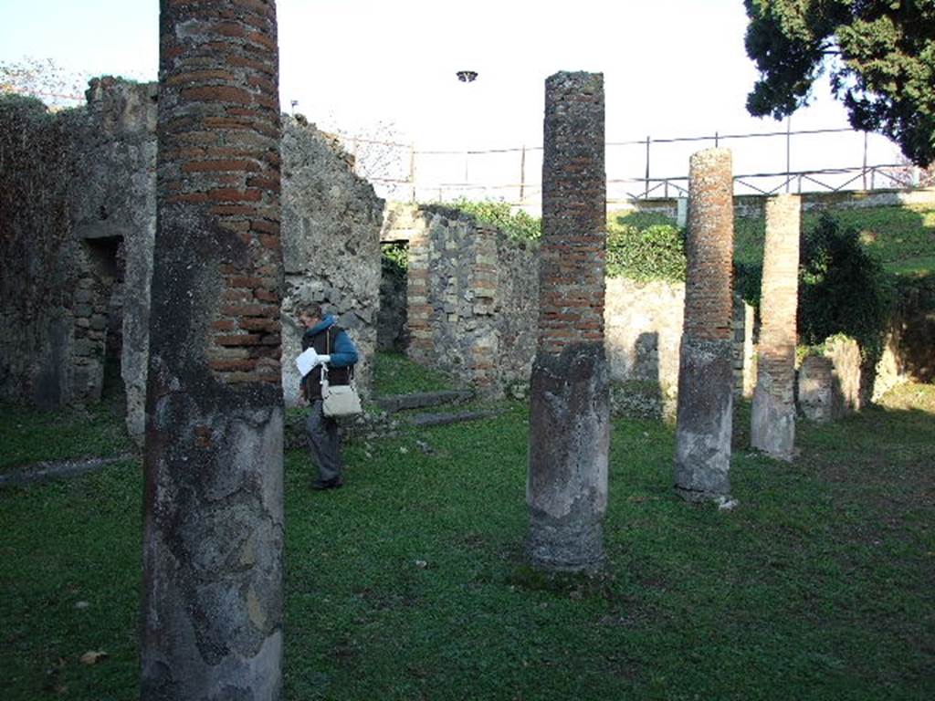 HGE12 Pompeii. December 2006. Looking north-east towards columns on north side of courtyard. According to Garcia y Garcia, the bombardment during the night of 18th September 1943 caused the destruction of four rooms of the ground floor. Also hit was part of the raised east side, and the toppling of a large portion of the portico. See Garcia y Garcia, L., 2006. Danni di guerra a Pompei. Rome: L’Erma di Bretschneider. (p.160)
