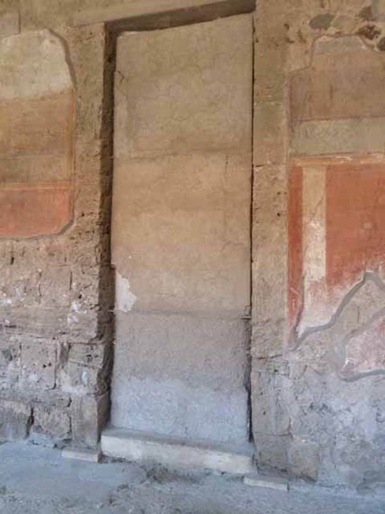 Villa of Mysteries, Pompeii. May 2012. Peristyle A, west wall with remains of wall decoration on north side of room 64, atrium entrance doorway.  Photo courtesy of Buzz Ferebee.
