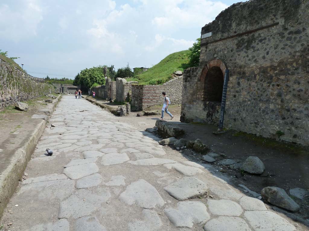Via dell’Abbondanza, south side. May 2010. 
Looking east from near the end of II.4 towards the junction with Vicolo dell’Anfiteatro, on the right.

According to Garcia y Garcia, two bombs fell on the north-east corner of this insula on 19th September 1943.
This damaged the perimeter wall on the Via dell’Abbondanza and the niche, which was then restored.
See Garcia y Garcia, L., 2006. Danni di guerra a Pompei. Rome: L’Erma di Bretschneider. (p.45-6).

