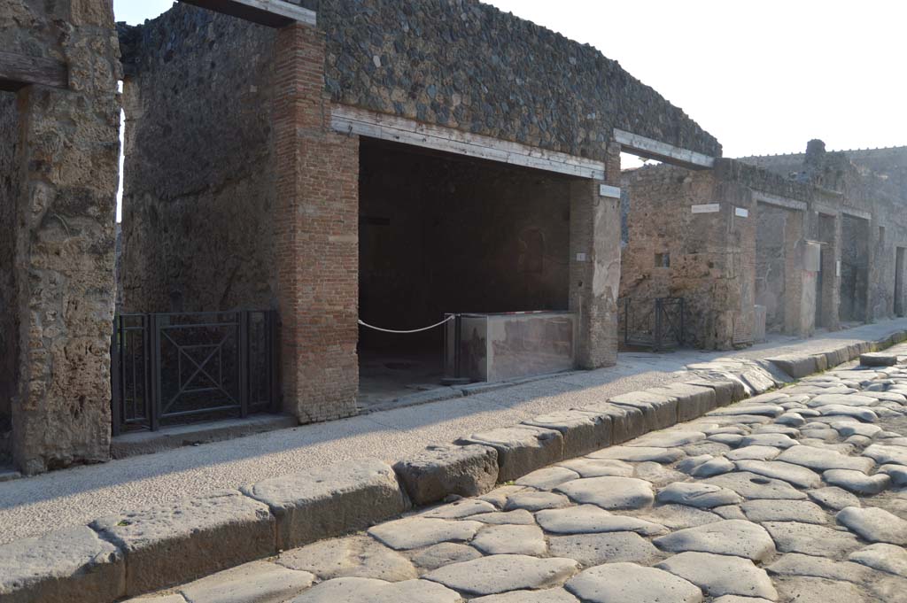 Via dell’Abbondanza, south side, Pompeii. October 2017. 
Looking south-west from I.8.2, on left, I.8.1, in centre, next to entrance to Vicolo dell’Efebo, and I.7, on right.
Foto Taylor Lauritsen, ERC Grant 681269 DÉCOR.
