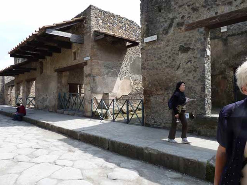 Via dell’Abbondanza, south side, Pompeii. October 2017. 
Looking south-east towards entrance doorway of I.11.1, in centre, and street altar in small roadway, on right.
Foto Taylor Lauritsen, ERC Grant 681269 DÉCOR.
