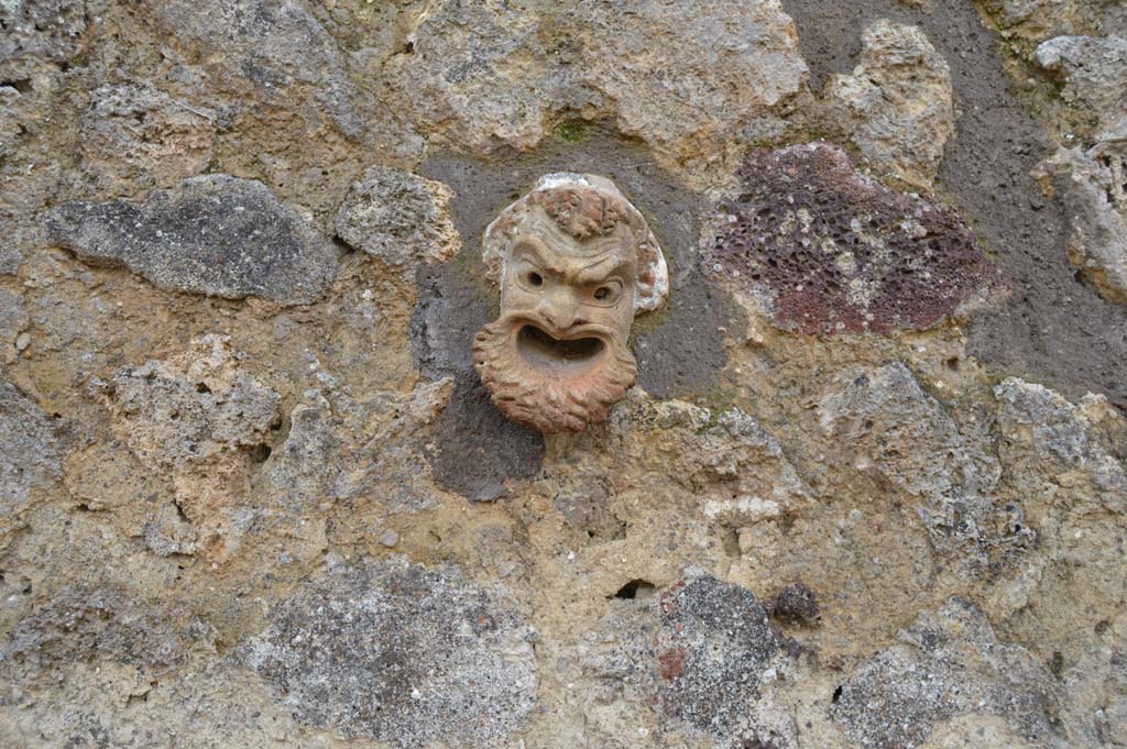 Vicolo del Centenario, Pompeii. March 2018. Detail of terracotta mask embedded in upper wall of IX.5.14-16. 
Foto Taylor Lauritsen, ERC Grant 681269 DÉCOR.


