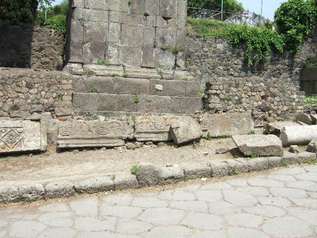 HGE06 Pompeii. May 2006. Base of tomb with columns and pieces of architectural frieze on ground.