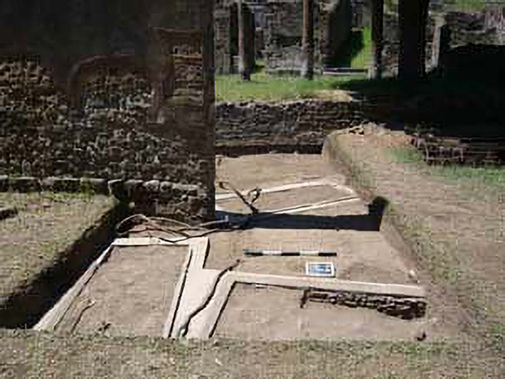 HGE15A Pompeii. 2009 re-excavation of three Samnite graves by the Via Consolare Project. 
The location of three graves is clustered around the base of the wall. 
The two graves in the metal frames are also visible on the other side of the gap in the wall.
Excavations in 2009 were carried out by the Via Consolare Project and their report commented that:
Extensive modern deposits were removed from the area, revealing three heavily reconstructed, irregularly-aligned inhumation cist-graves. 
It is likely that these constructions are the result of the excavations of A. Maiuri in the 1930-40’s and were a component of his preparations of the Villa for general display that included replanting the viridarium and running water to the nymphaeum.
Photo courtesy of the Via Consolare Project. See http://www.viaconsolareproject.org/research2009.html
