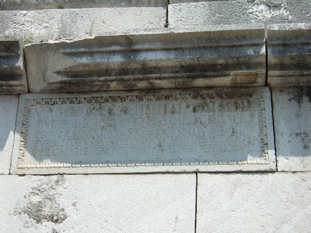 HGE37 Pompeii. May 2006. Marble plaque on south side. 
On the plaque is the inscription: 
M. ALLEIO LVCCIO LIBELLAE PATRI AEDILI
II VIR PRAEFECTO QVINQ(uennali) ET M. ALLEIO LIBELLAE F
DECVRIONI VIXIT ANNIS XVII LOCVS MONVMENTI
PVBLICE DATVS EST ALLEIA M F DECIMILLA SACERDOS
PVBLICA CERERIS FACIVNDVM CVRAVIT VIRO ET FILIO

This differs from the east side plaque where the last word is FILO rather than FILIO. 
The plaque is also wider and the inscription is on fewer (five) lines.
According to Epigraphik-Datenbank Clauss/Slaby (See www.manfredclauss.de) this reads

M(arco) Alleio Luccio Libellae patri aedile
IIvir(o) praefecto quinq(uennali) et M(arco) Alleio Libellae f(ilio)
decurioni vixit annis XVII locus monumenti
publice datus est Alleia M(arci) f(ilia) Decimilla Sacerdos
publica Cereris faciundum curavit viro et filio      [CIL X 1036 – first part]
