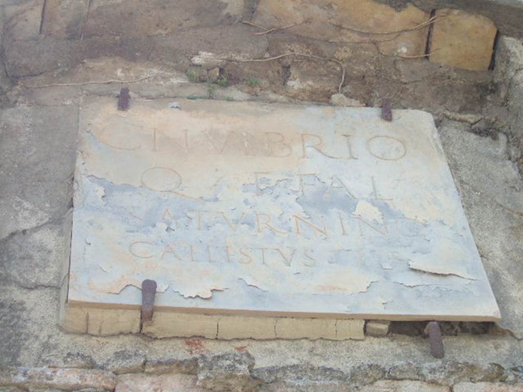 HGW23 Pompeii. May 2006. Marble plaque with Latin inscription.

CN VIBRIO
Q F FAL
SATVRNINO
CALLISTVS LIB

According to Epigraphik-Datenbank Clauss/Slaby (See www.manfredclauss.de) this reads

Cn(aeo) Vibrio
Q(uinti) f(ilio) Fal(erna)
Saturnino
Callistus lib(ertus)      [CIL X 1033]

Mau translated this as 

To the memory of Gnaeus Vibrius Saturninus son of Quintus, of the tribe Falerna; erected by his freedman Callistus.

See Mau, A., 1907, translated by Kelsey F. W. Pompeii: Its Life and Art. New York: Macmillan. (. 424).