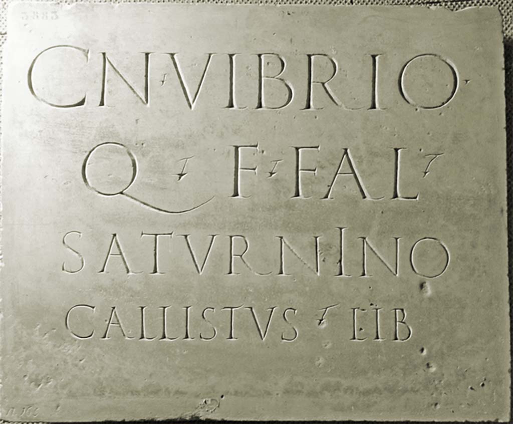 HGW23 Pompeii. Original marble plaque with Latin inscription to CN. Vibrio Saturnino Callistus.
Now in Naples Archaeological Museum. Inventory number 3883.
According to Virginia Campbell this reads
Cn(aeo) Vibrio
Q(uinti) f(ilio) Fal(erna tribu)
Saturnino
Callistus (mulieris) lib(ertus)      [CIL X 1033]

and translates as
To Gnaeus Vibrius Saturninus, son of Quintius, member of the Falernian tribe, (built by) Callistus, freedman of a woman.

See Campbell V., 2015. The tombs of Pompeii: organization, space, and society. New York-London: Routledge, p. 174, p. 112.
