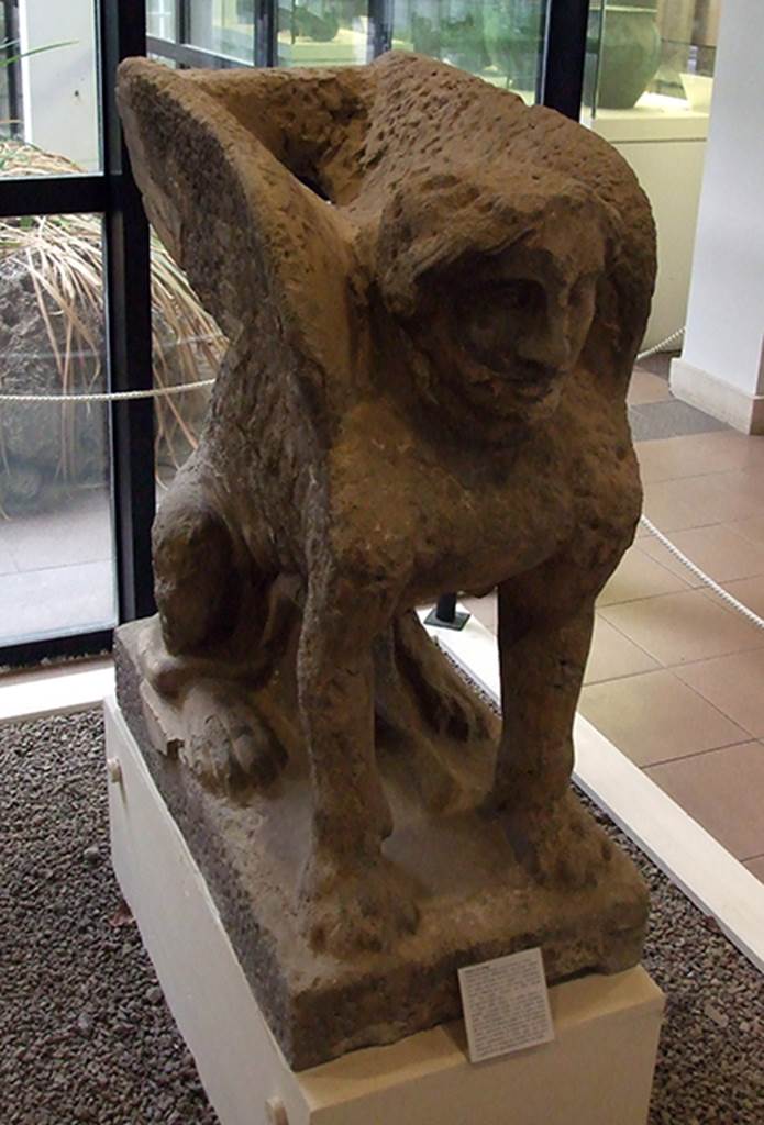 Pompeii, Villa rustica nel Fondo di Antonio Prisco. Entrance A side pillar.
Statue of a seated sphinx with feline body, female head and large wings.
Possibly dated to 2nd century BC.
It would have originally been a funeral monument but by 79AD it had been placed, with another similar one (of which only the head was found), at the entrance to the villa.
Now in Boscoreale Antiquarium. SAP inventory number 25896.
