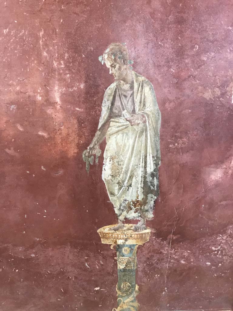Complesso dei triclini in località Moregine a Pompei. April 2019. Triclinium C, west wall.
Robed figure with crown of leaves and holding what appears to be a scroll. A poet or philosopher?
Photo courtesy of Rick Bauer.

