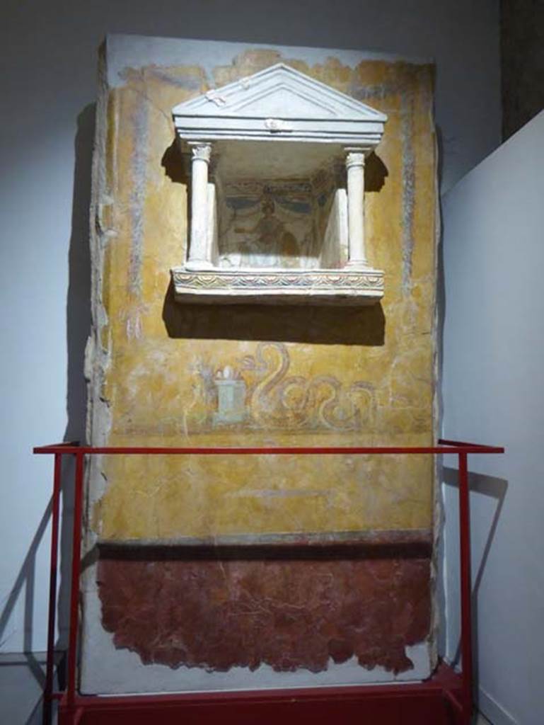 Gragnano, Villa rustica in Località Carmiano, Villa A. June 2017. Aedicula lararium. 
From dividing pilaster between kitchen room 4 and room 2. 
Stabiae Antiquarium, inventory number 63688.
Photo courtesy of Michael Binns.
Lararium with niche and painting of serpent underneath. 
The lararium had a triangular pediment supported by two Corinthian columns.
The painting at the rear showed an enthroned Minerva with breastplate, helmet, shield, lance in the left hand and gilded/golden plate in the right. 
Underneath the lararium, a painted serpent was found, moving to the right towards an altar on which was deposited the offerings. 
See Fröhlich, T., 1991. Lararien und Fassadenbilder in den Vesuvstädten. Mainz: von Zabern, p. 303, L122, Taf. 15,1.
