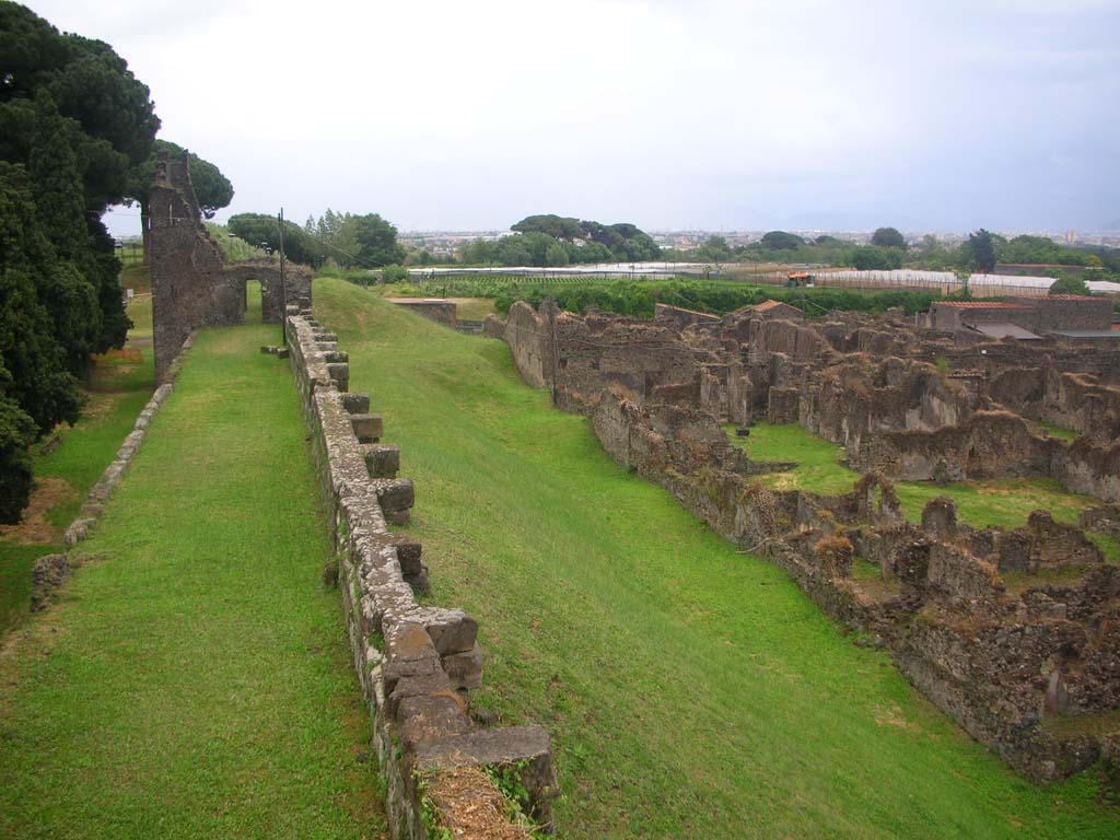 City Walls on north side of Pompeii. May 2010. 
Looking east line of walls towards Tower X, with north side of insulas VI.15, and VI.11. Photo courtesy of Ivo van der Graaff.
