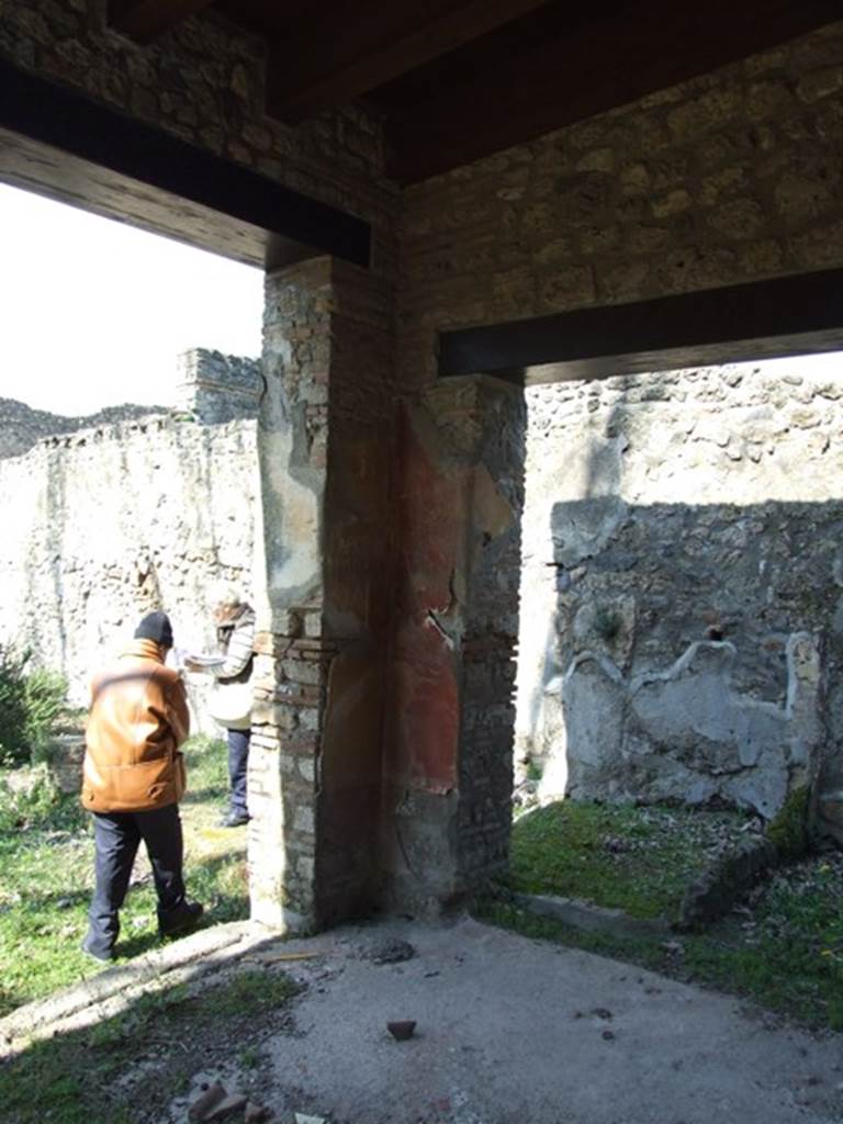 II.1.12 Pompeii.  March 2009. Pillar on north side. Various graffiti were found on the pillars at each side of the door.  Behind the pillar, against the north wall, can be seen the second small storeroom.
